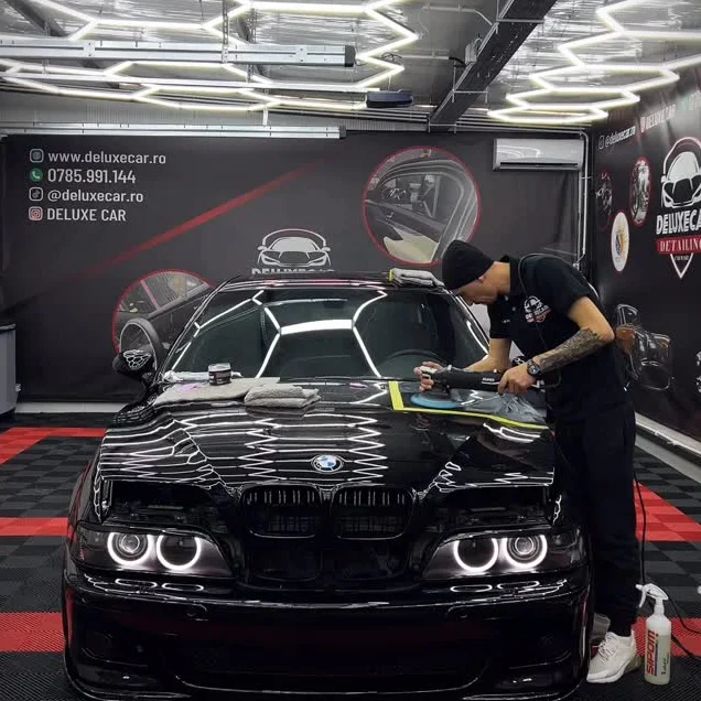 Lucrare în desfășurare pe un BMW negru, în atelierul DeluxeCar